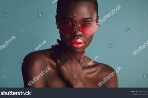stock-photo-close-up-of-a-stunning-woman-with-vibrant-makeup-wearing-sunglasses-african-female-model-looking-1725716314