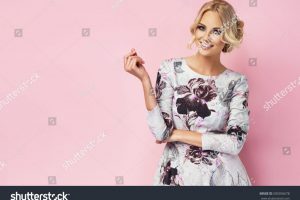 stock-photo-fashion-photo-of-a-beautiful-young-woman-in-a-pretty-dress-with-flowers-posing-over-pink-background-500356678