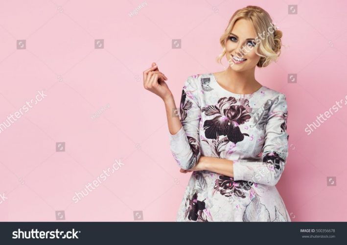 stock-photo-fashion-photo-of-a-beautiful-young-woman-in-a-pretty-dress-with-flowers-posing-over-pink-background-500356678