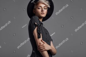 stock-photo-fashion-portrait-of-female-model-with-blond-short-hair-wear-black-hat-and-fashionable-dress-1219467658