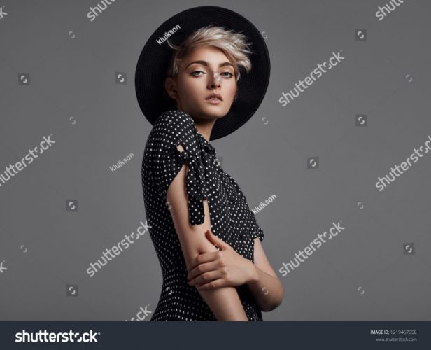 stock-photo-fashion-portrait-of-female-model-with-blond-short-hair-wear-black-hat-and-fashionable-dress-1219467658