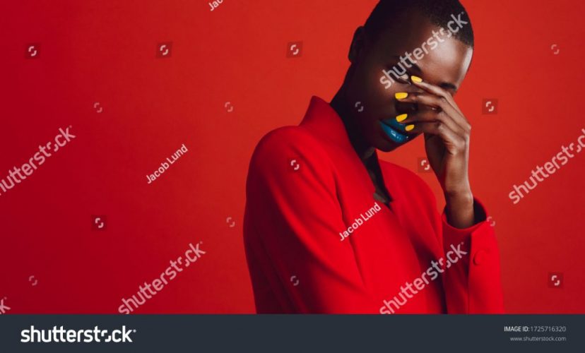 stock-photo-glamorous-female-model-on-red-background-african-woman-with-buzz-cut-hairstyle-and-vibrant-makeup-1725716320