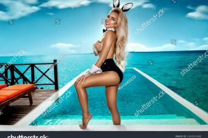 stock-photo-sexy-blonde-model-dressed-in-easter-bunny-costume-and-bunny-ears-is-standing-in-pool-on-maldives-2143533369