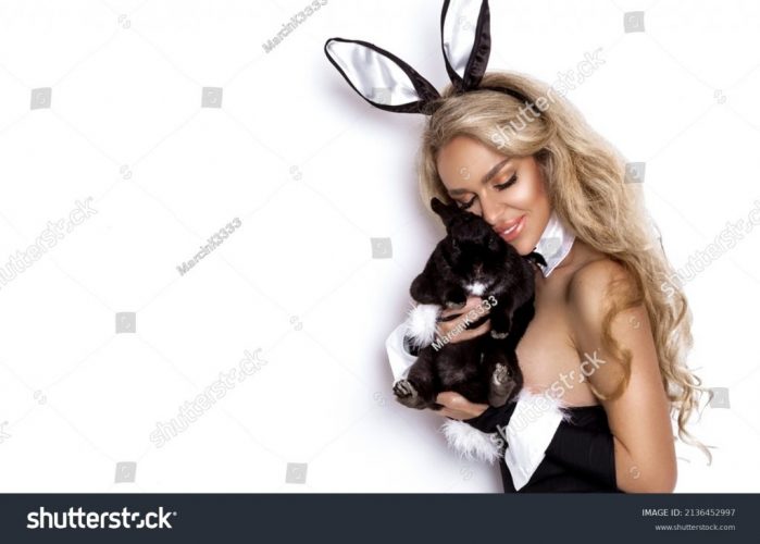 stock-photo-sexy-blonde-woman-dressed-in-easter-bunny-costume-is-standing-on-a-white-background-and-is-holding-2136452997